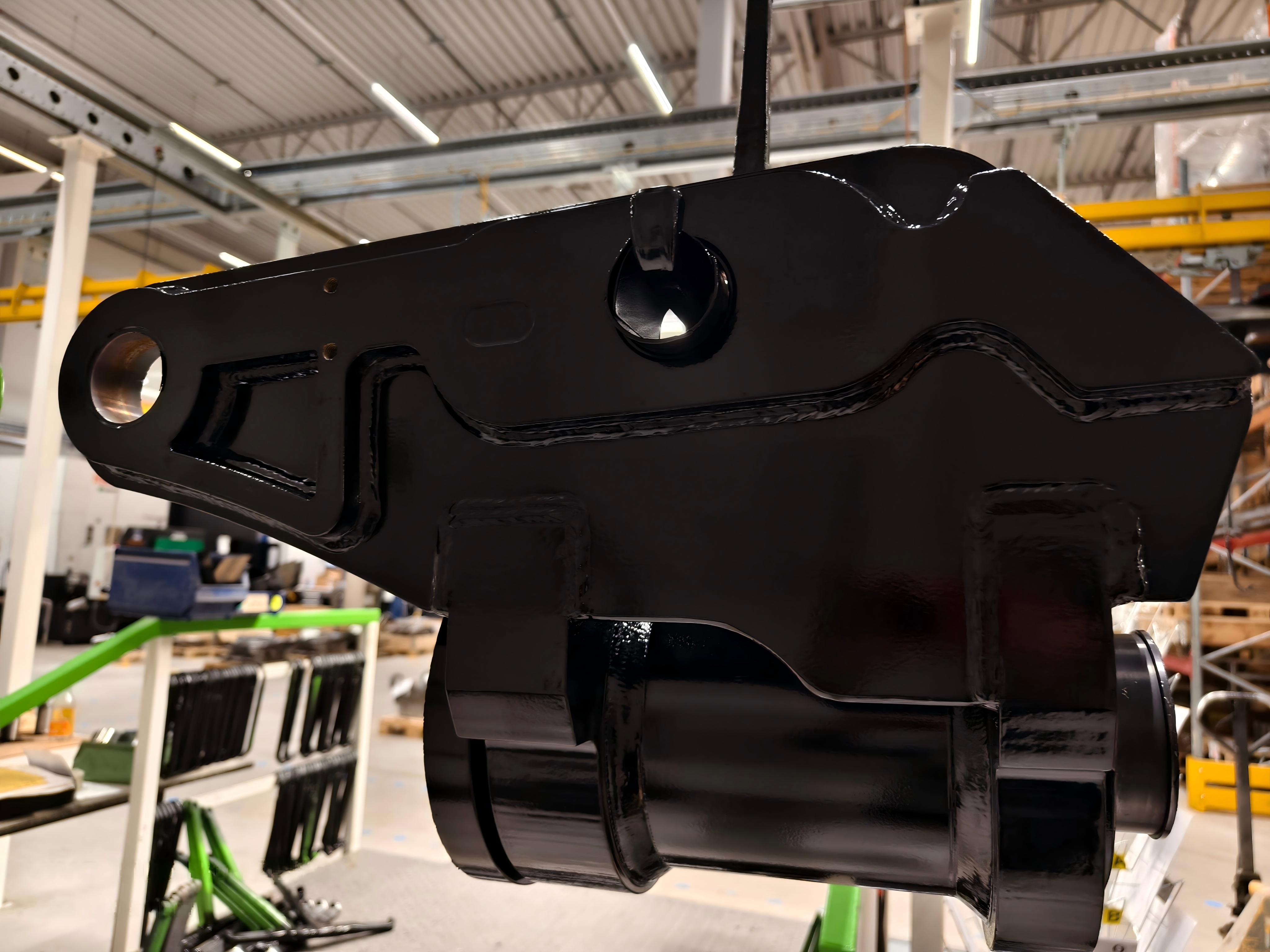 Excavator tilt coupler with rotary tilt actuator in workshop